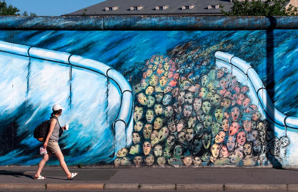 Volunteers painting colorful murals on walls during an urban clean-up event